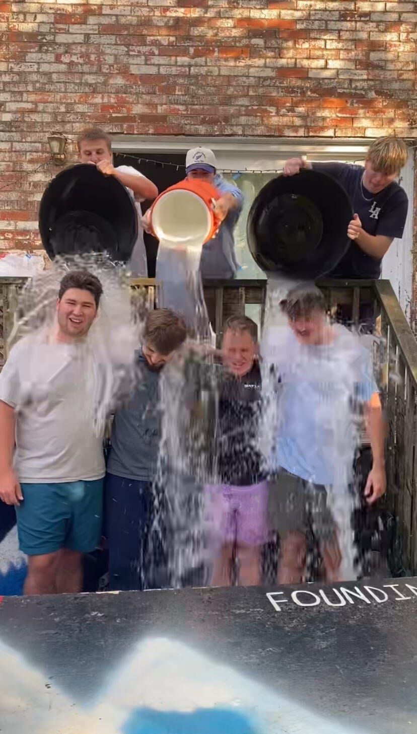 Brothers dumping buckets of ice water on each other